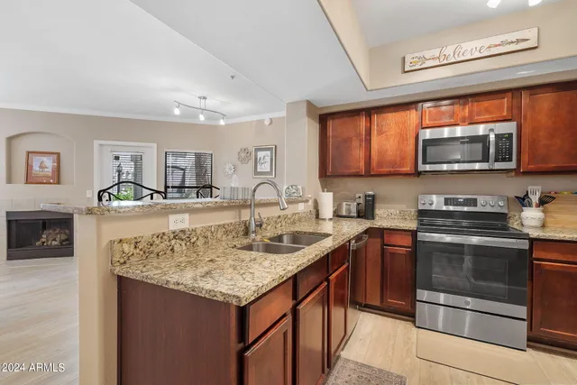 a kitchen with stainless steel appliances granite countertop a stove top oven a sink and a microwave