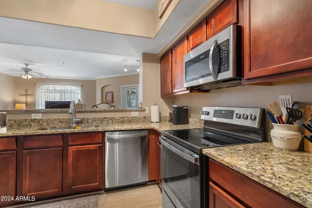 a kitchen with stainless steel appliances granite countertop a stove and a microwave