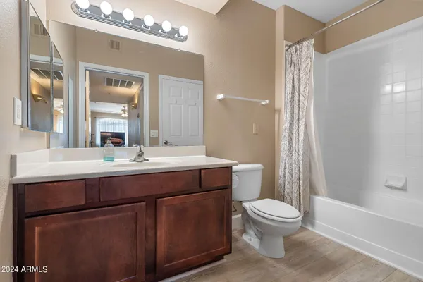 a bathroom with a toilet a sink a mirror a bathtub and shower