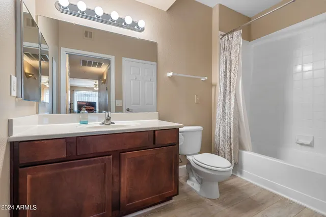 a bathroom with a toilet a sink a mirror a bathtub and shower