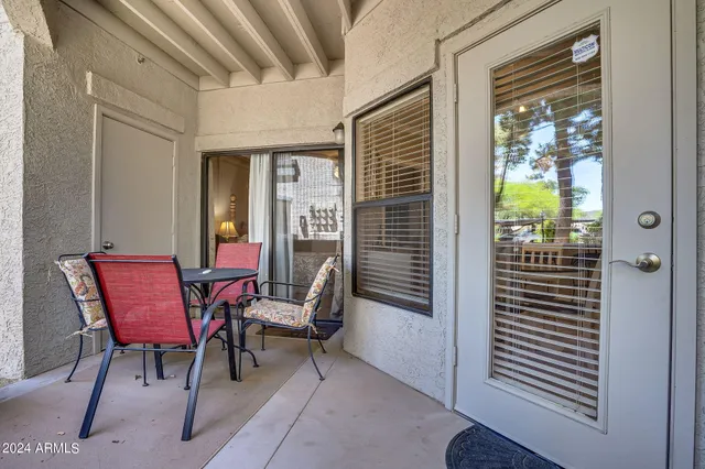 a balcony with chairs and a potted plant
