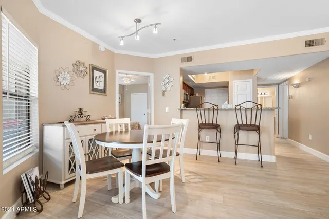 a dining room with a wooden table and chairs