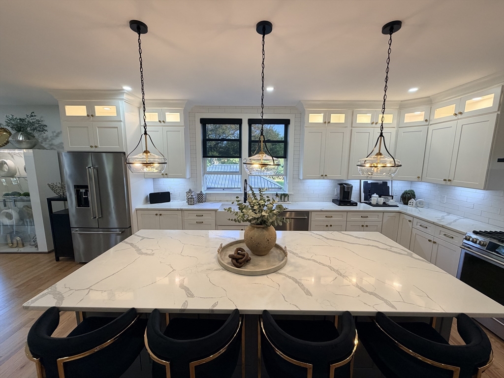 6 Rivendell Lane Millis, MA 02054 - Photo 5 of 33 a kitchen with a dining table chairs and white wooden floor