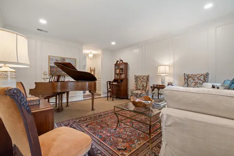 a living room with furniture a rug and a piano