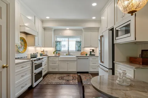 a kitchen with a sink appliances a counter space and a window