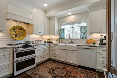 a kitchen with stainless steel appliances a refrigerator a stove a dining table and chairs with wooden floor