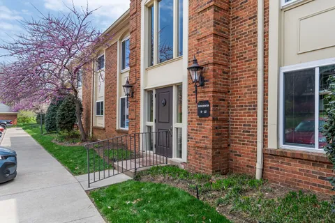 a view of a brick house with a yard and pathway