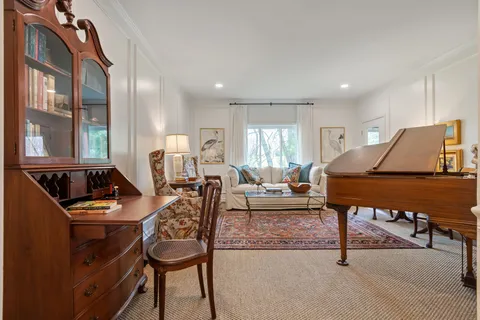 a living room with furniture and a piano