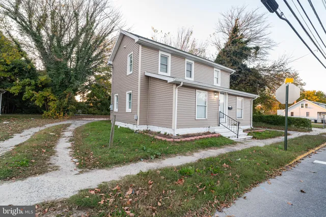 a view of a yard in front of a house with large tree