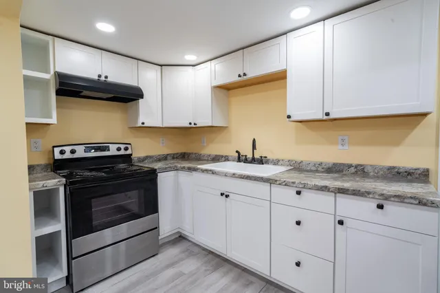 a kitchen with granite countertop cabinets stainless steel appliances and a sink