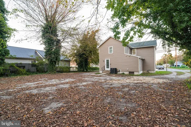 a view of a house with a yard and a large tree