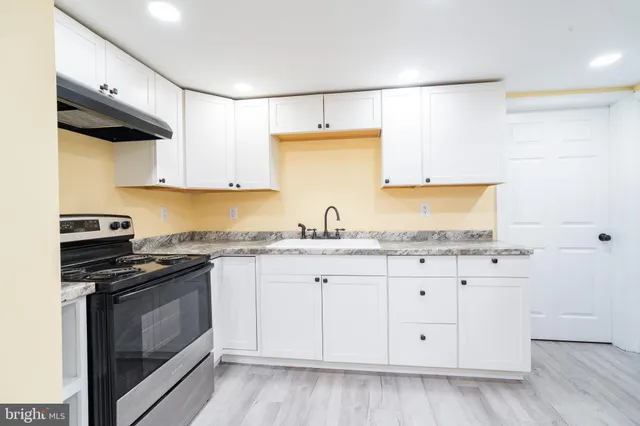 a kitchen with granite countertop white cabinets and white appliances