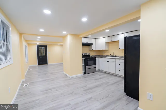 a view of kitchen with kitchen island granite countertop wooden floors and wide window