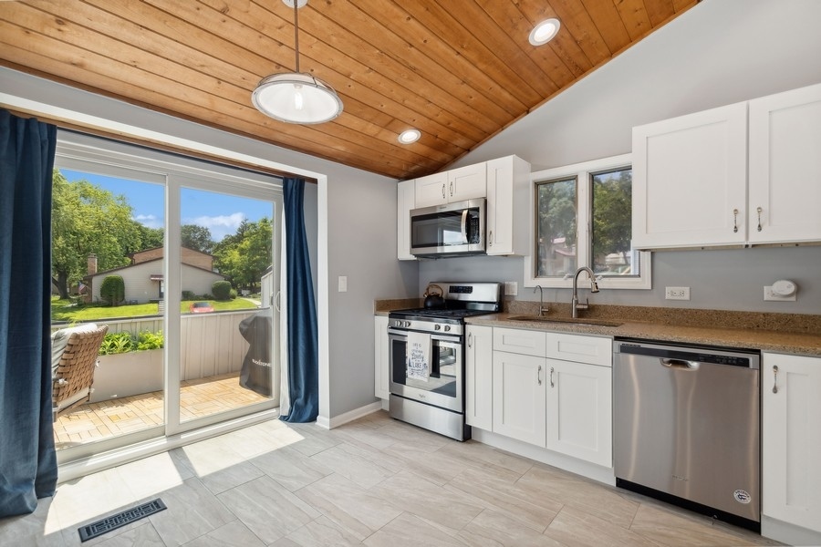 21 Mineola Road Fox Lake, IL 60020 - Photo 11 of 21 a kitchen with stainless steel appliances granite countertop a stove sink and microwave