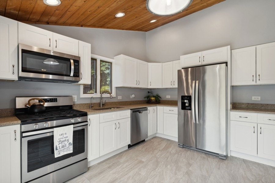 21 Mineola Road Fox Lake, IL 60020 - Photo 12 of 21 a kitchen with stainless steel appliances a stove microwave and sink