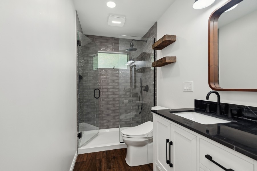 21 Mineola Road Fox Lake, IL 60020 - Photo 16 of 21 a bathroom with a granite countertop sink a toilet a mirror and shower