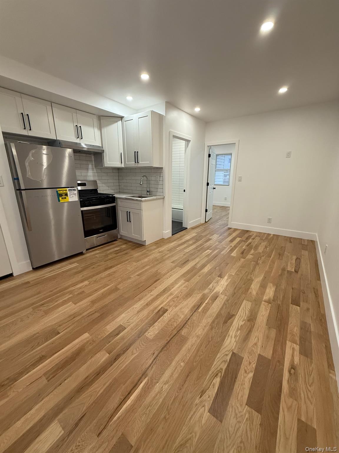 Undisclosed Address Queens, NY 11416 - Photo 1 of 10 a open kitchen with kitchen island a sink stainless steel appliances and white cabinets