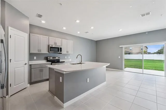a kitchen with a sink a stove and cabinets