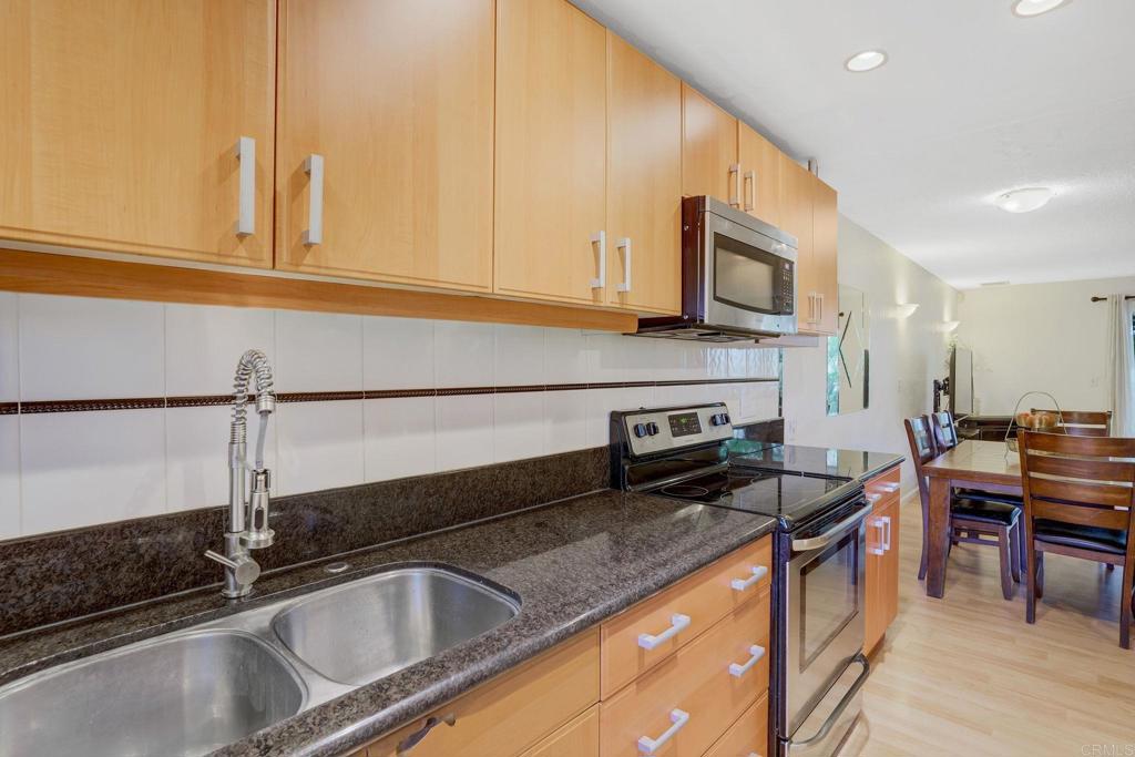 150 E Street, Unit A1 Chula Vista, CA 91910 - Photo 9 of 55 a kitchen with stainless steel appliances granite countertop a sink stove and microwave