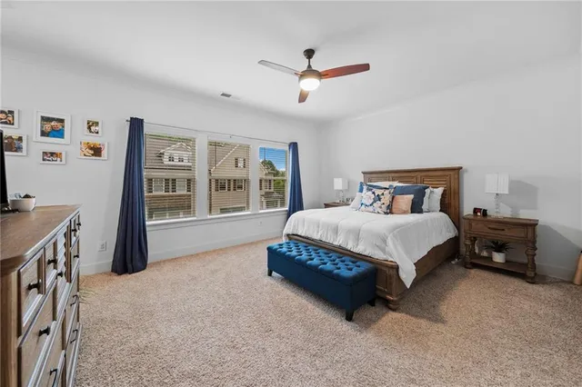 a spacious bedroom with a large bed and a chandelier