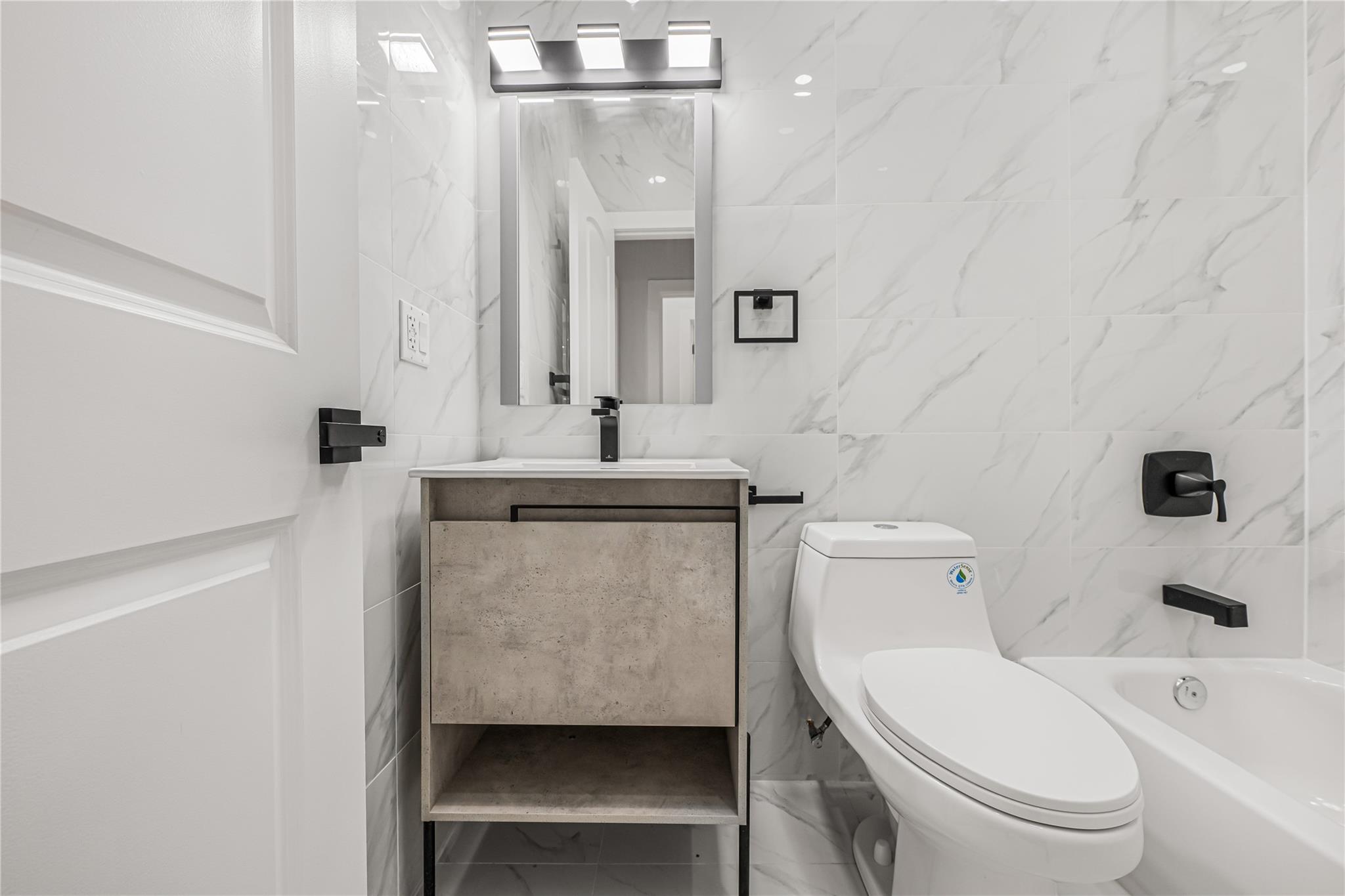 164 Atkins Avenue, Unit 2 Brooklyn, NY 11208 - Photo 11 of 23 a bathroom with a toilet a sink and a mirror