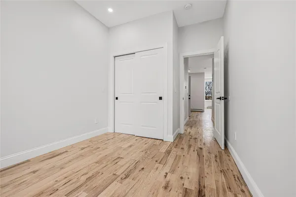 a view of a room with wooden floor and a bathroom