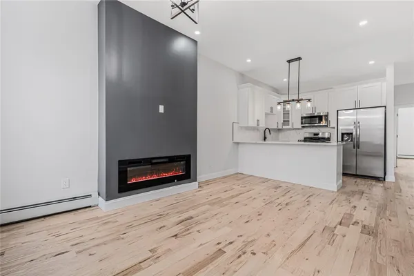 a kitchen with stainless steel appliances a refrigerator and a wooden floor