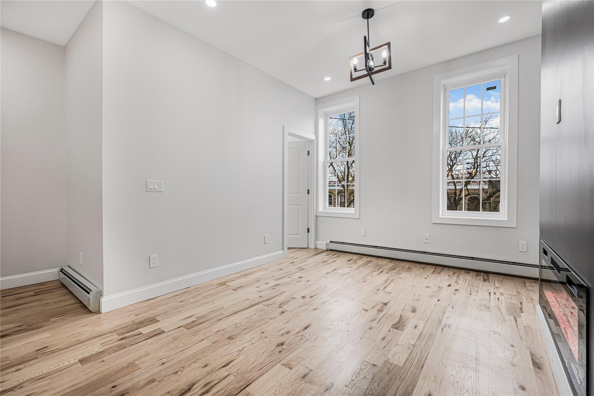 164 Atkins Avenue, Unit 2 Brooklyn, NY 11208 - Photo 16 of 23 a view of an empty room with wooden floor and a window
