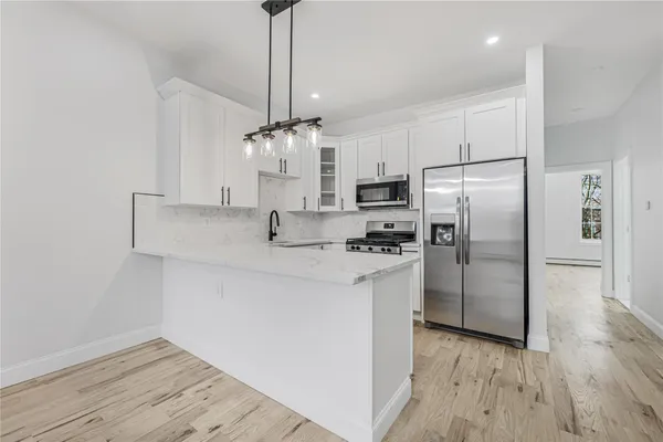 a kitchen with stainless steel appliances granite countertop a stove a sink and a microwave
