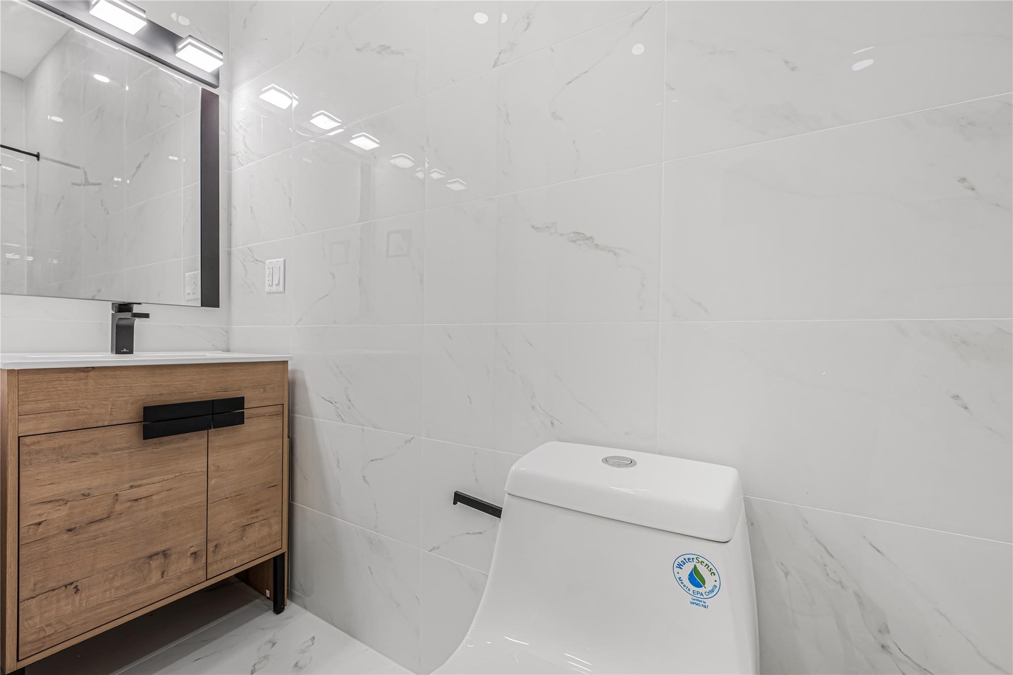 164 Atkins Avenue, Unit 2 Brooklyn, NY 11208 - Photo 5 of 23 a bathroom with a sink a toilet and mirror