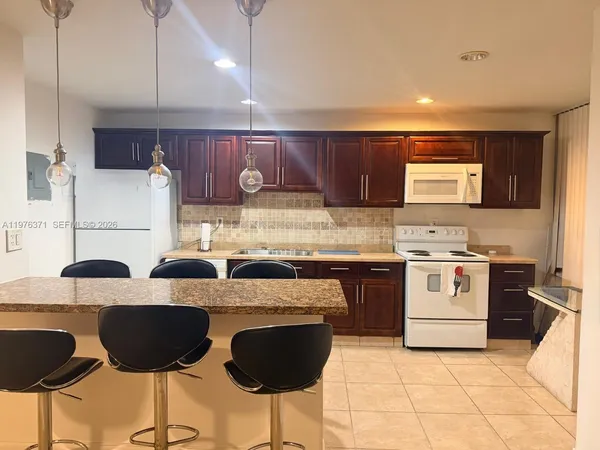 a kitchen with cabinets and chairs
