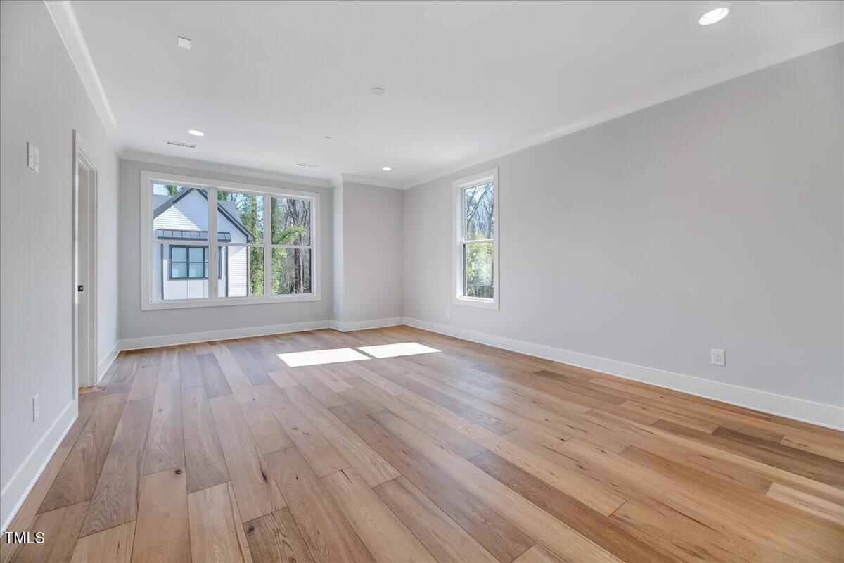811 Maple Berry Lane, Unit 106 Raleigh, NC 27607 - Photo 12 of 30 an empty room with wooden floor and windows