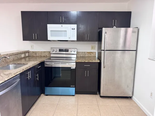 a kitchen with stainless steel appliances granite countertop a sink and a microwave
