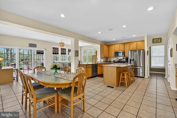 a kitchen with a dining table chairs and white appliances