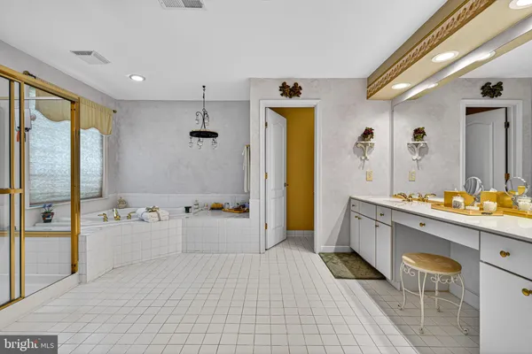 a bathroom with a tub sink and mirror