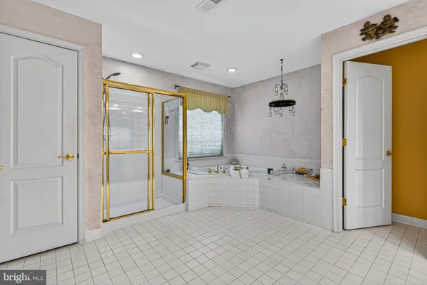 a spacious bathroom with a tub shower and mirror