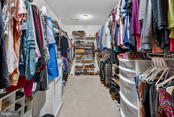 a view of walk in closet with clothes