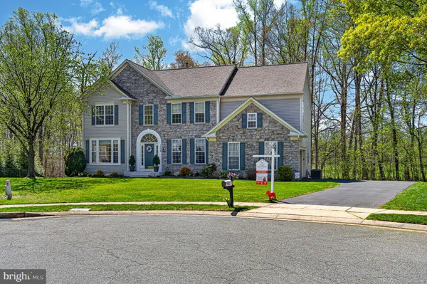 a view of a house with a big yard and large trees