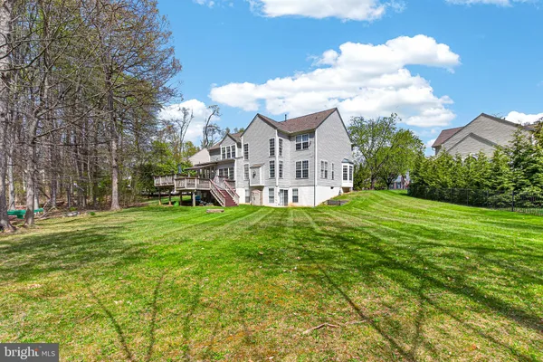 a view of a house with a big yard and large trees