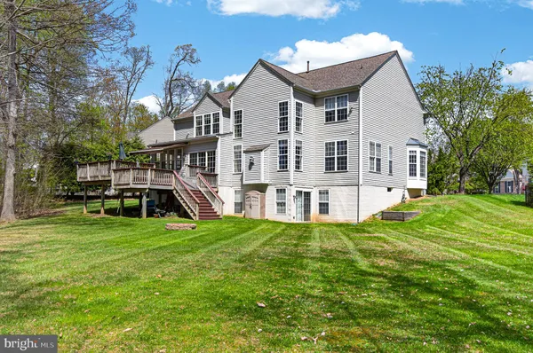 a view of a house with backyard and trees