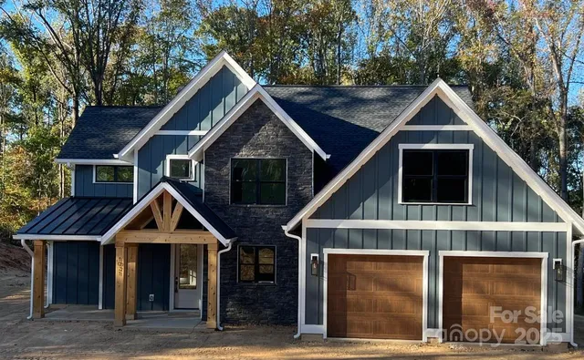 a house view with a wooden fence and large trees