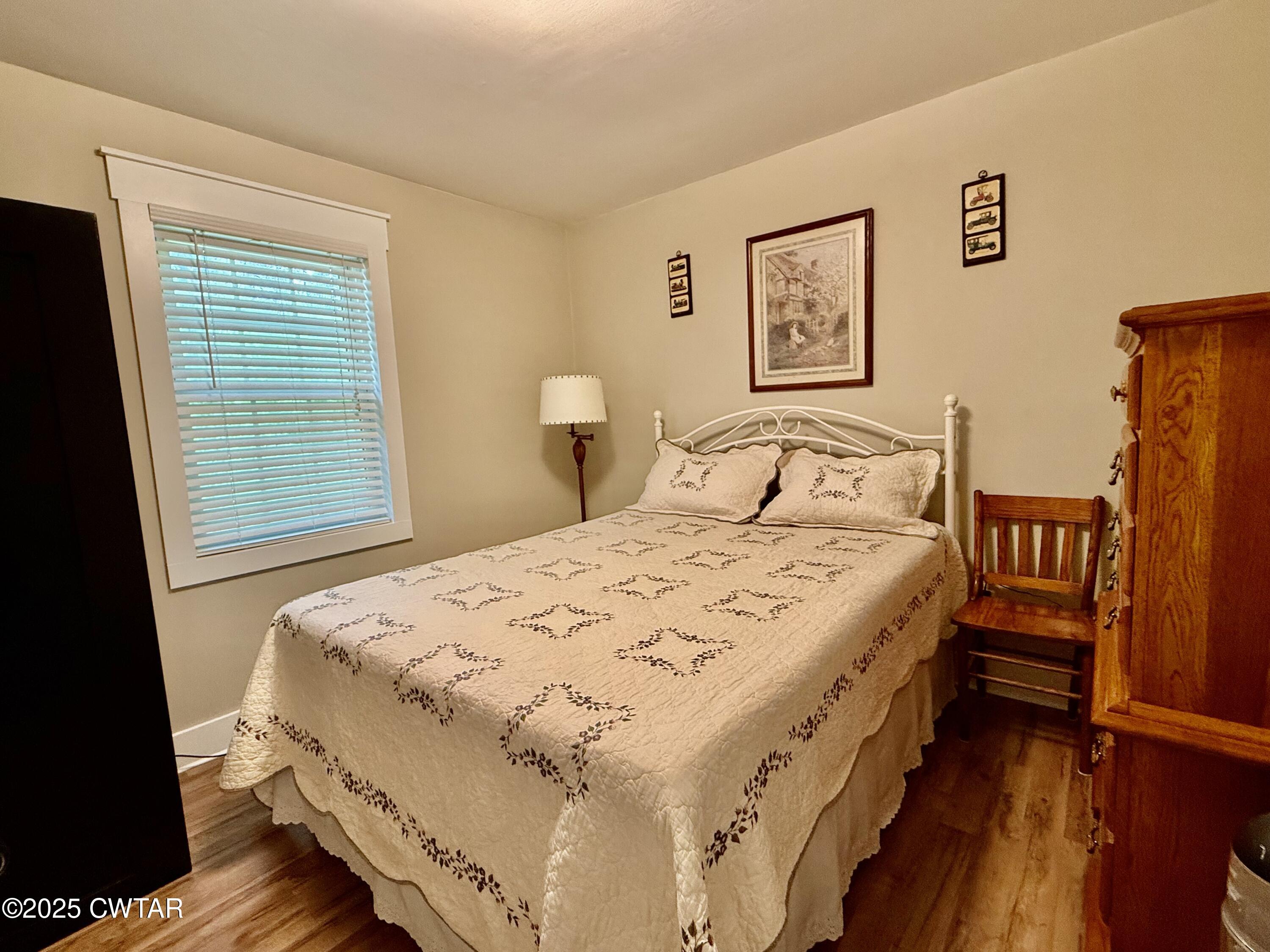 0 Webb Store Road Hornbeak, TN 38232 - Photo 12 of 22 a bedroom with a bed next to a window with wooden floor
