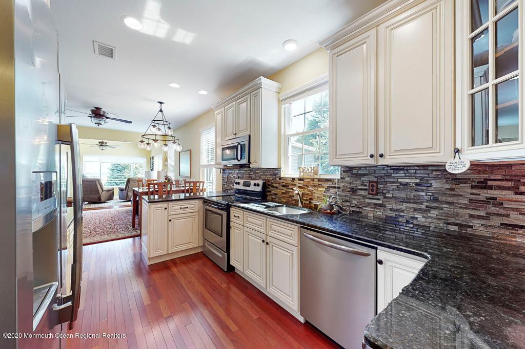 43 Portland Road Highlands, NJ 07732 - Photo 14 of 47 a kitchen with stainless steel appliances granite countertop a refrigerator a sink dishwasher a stove and white countertops with wooden floor