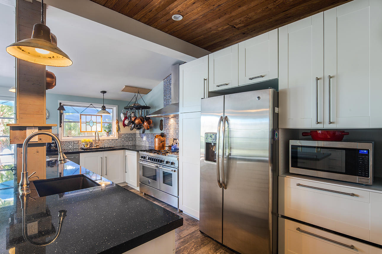 1425 Laird Street Key West, FL 33040 - Photo 7 of 26 a kitchen with a refrigerator and a stove top oven