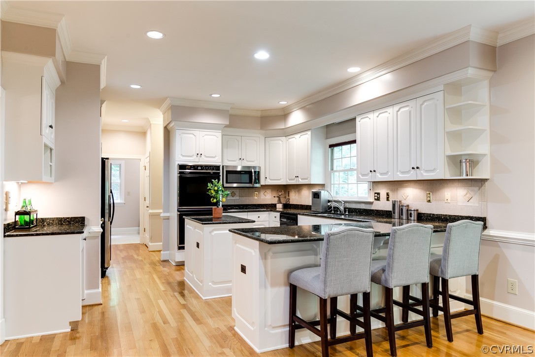 3830 Reeds Landing Circle Midlothian, VA 23113 - Photo 11 of 50 a kitchen with kitchen island granite countertop a sink a stove a refrigerator and white cabinets with wooden floor