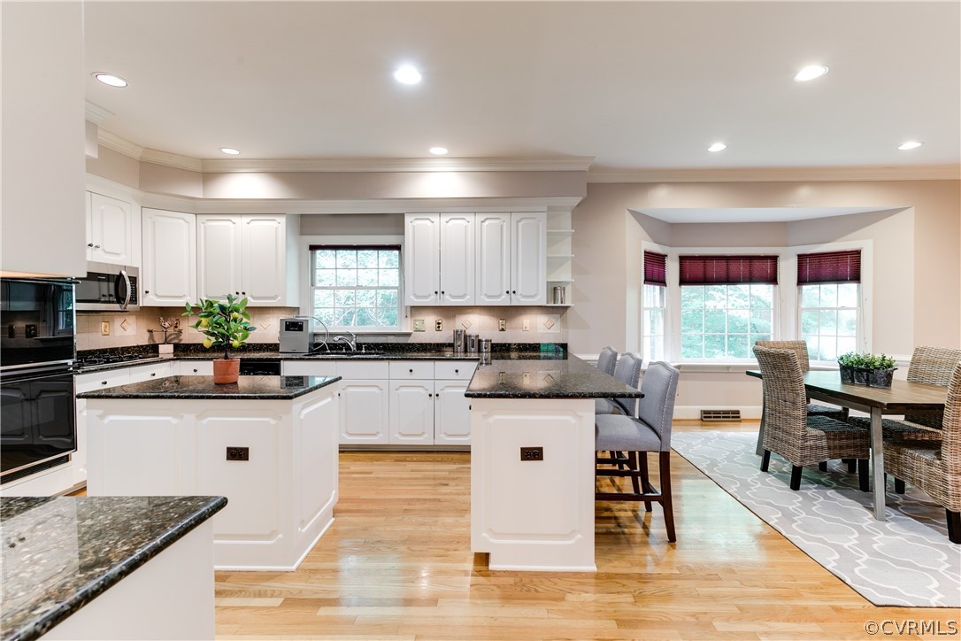 3830 Reeds Landing Circle Midlothian, VA 23113 - Photo 10 of 50 a kitchen with stainless steel appliances granite countertop a stove top oven a sink dishwasher and white cabinets with wooden floor
