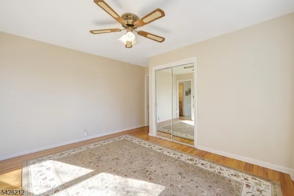 an empty room with a window and a ceiling fan