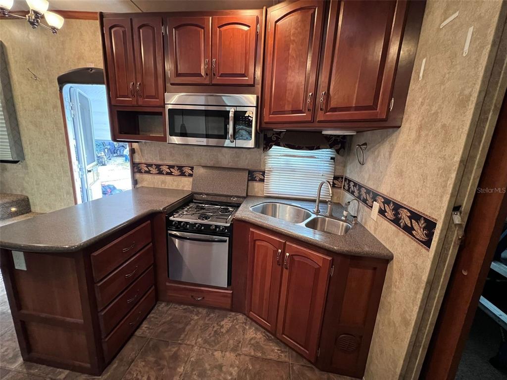 3000 Clarcona Road, Unit 343 Apopka, FL 32703 - Photo 11 of 15 a kitchen with stainless steel appliances granite countertop a sink stove and microwave