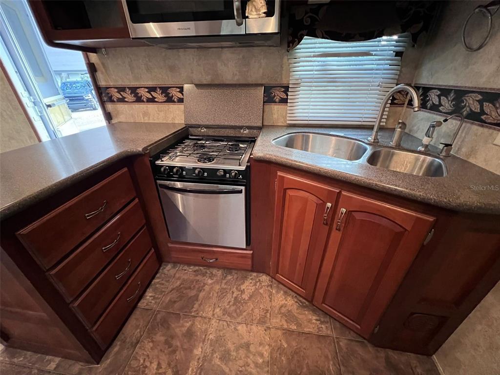 3000 Clarcona Road, Unit 343 Apopka, FL 32703 - Photo 12 of 15 a kitchen with granite countertop a stove and a sink