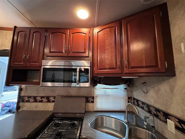 a kitchen with granite countertop cabinets and black stove top oven
